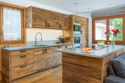 a kitchen with wooden cabinets and a counter top at Chalet des Souchettes - Chamonix All Year in Chamonix-Mont-Blanc