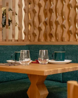 a wooden table with three wine glasses on it at Hôtel Restaurant la Couronne in Chamonix-Mont-Blanc