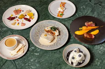 a table with plates of food and a cup of coffee at Hôtel Restaurant la Couronne in Chamonix-Mont-Blanc