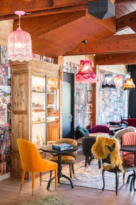 a room with many chairs and tables and lamps at Mamie Megève in Megève