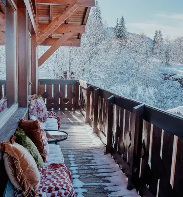 a balcony with a view of the snow covered trees at Mamie Megève in Megève