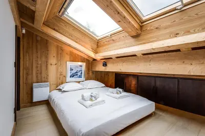 a bedroom with a large bed with a skylight at Chalet Rass in Chamonix-Mont-Blanc
