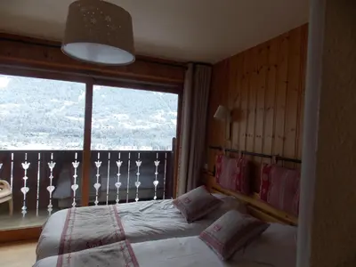 a bedroom with a bed and a large window at Edelweiss in Samoëns