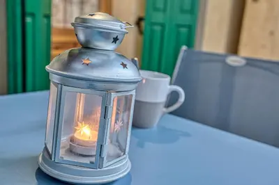 a lantern sitting on a table with a candle at Studio 