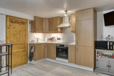 a kitchen with wooden cabinets and a microwave at Studio 