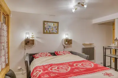a bedroom with a bed with a red blanket at Studio 