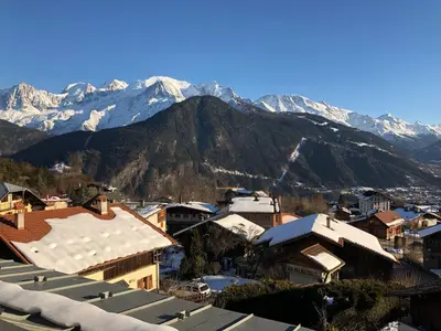 a city with snow covered mountains in the background at Meridies in Plateau dʼAssy