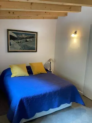 a blue bed with two yellow pillows in a bedroom at Meridies in Plateau dʼAssy