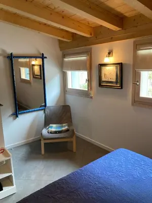 a bedroom with a bed and a chair and a mirror at Meridies in Plateau dʼAssy