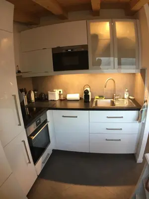 a kitchen with white cabinets and a sink at Meridies in Plateau dʼAssy