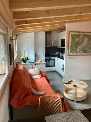 a living room with a couch and a kitchen at Meridies in Plateau dʼAssy