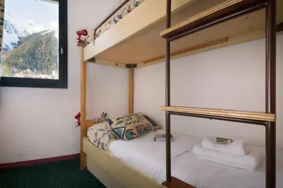 a bedroom with two bunk beds and a window at Chamonix Sud - Marguerite B215 - Happy Rentals in Chamonix-Mont-Blanc