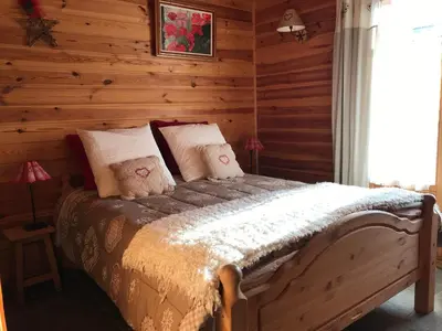 a bedroom with a bed in a log cabin at Chalet La Grande Ourse in Saint-Gervais-les-Bains