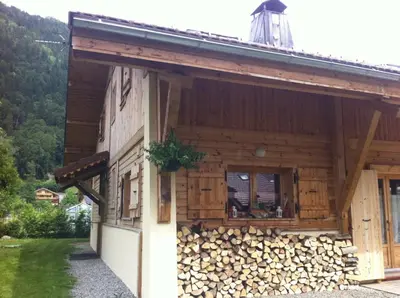 a wooden house with a pile of fire wood at Chalet La Grande Ourse in Saint-Gervais-les-Bains