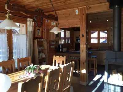 a dining room and kitchen in a log cabin at Chalet La Grande Ourse in Saint-Gervais-les-Bains