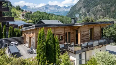 a log cabin with snow on the porch at Chalet Base Camp in Les Houches