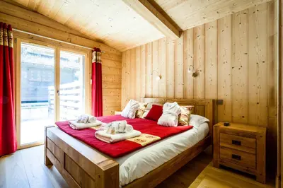 a bedroom with a large bed with towels on it at Chalet Base Camp in Les Houches