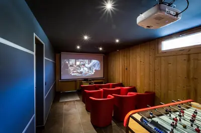 a game room with red chairs and a screen at Chalet Base Camp in Les Houches