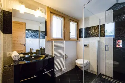 a bathroom with a sink and a toilet and a shower at Chalet Base Camp in Les Houches