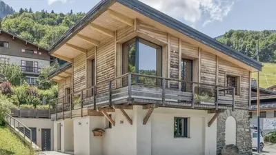 a log cabin with a balcony in the snow at Chalet Base Camp in Les Houches