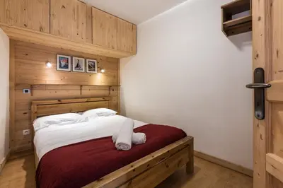a bedroom with a large bed with wooden walls at Apartment Marcel - Cosy Chamonix Haven Mont Blanc in Chamonix-Mont-Blanc