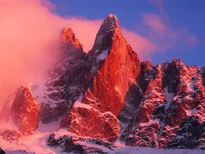 a mountain covered in snow with a red sky at Apartment Marcel - Cosy Chamonix Haven Mont Blanc in Chamonix-Mont-Blanc