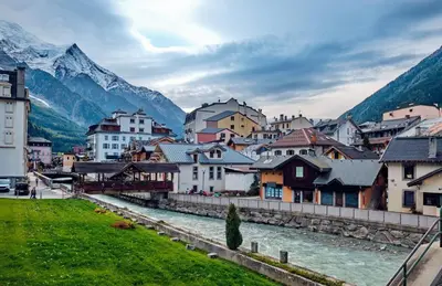 a town with a river and mountains in the background at Apartment Marcel - Cosy Chamonix Haven Mont Blanc in Chamonix-Mont-Blanc