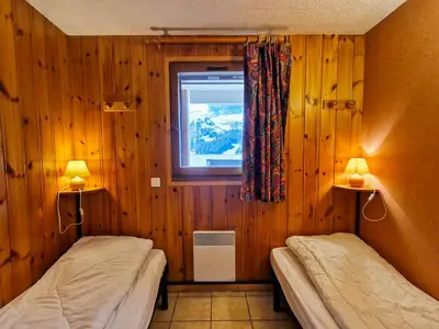 two beds in a room with wooden walls and a window at Appartement spacieux au centre station avec balcon, 3 pièces pour 8 personnes - FR-1-425-2 in Flaine