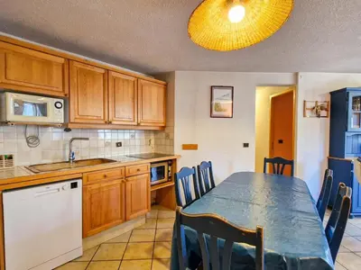 a kitchen with a table and chairs and a kitchen with a table and a kitchen at Appartement spacieux au centre station avec balcon, 3 pièces pour 8 personnes - FR-1-425-2 in Flaine