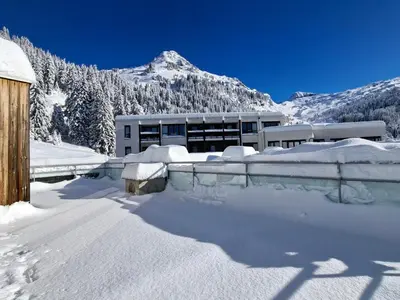 a building covered in snow with a mountain in the background at Appartement lumineux 4 pièces à Flaine, 8 personnes, terrasse, accès spa - FR-1-425-18 in Flaine