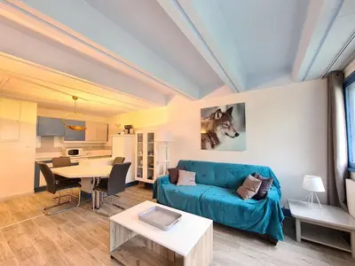 a living room with a blue couch and a table at Appartement rénové près des pistes - Balcon, 5/6 pers. - FR-1-425-47 in Flaine