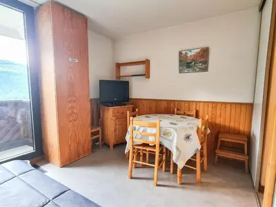 a dining room with a table and chairs and a television at Studio lumineux au centre de Flaine avec balcon, équipé pour 4 personnes - FR-1-425-80 in Flaine