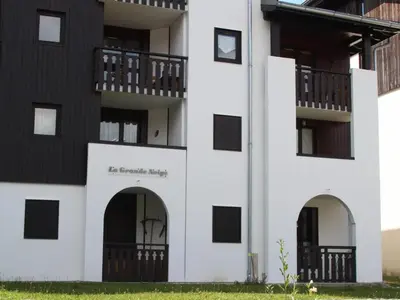 a white building with arches and a balcony at Appartement cosy 2 pièces pour 4 à Morillon 1100, proche pistes - FR-1-815-65 in Morillon