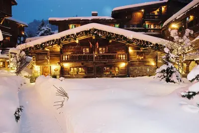 a log cabin in the snow at night at Fer à Cheval in Megève