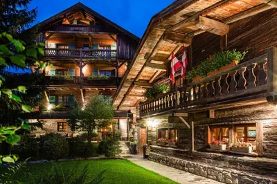 an exterior view of a log house with a yard at Fer à Cheval in Megève