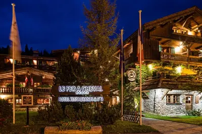 a sign in front of a building at night at Fer à Cheval in Megève