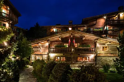 a wooden house with lights on it at night at Fer à Cheval in Megève
