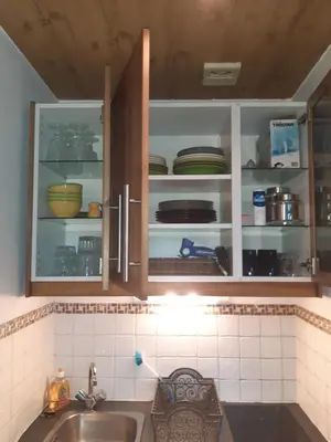 a kitchen with a sink and cabinets filled with dishes at Le Carlton in Chamonix-Mont-Blanc