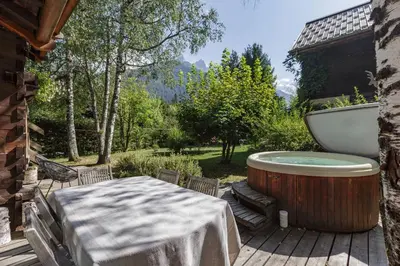a bath tub sitting on a deck with a table at Mazot les Tines in Chamonix-Mont-Blanc