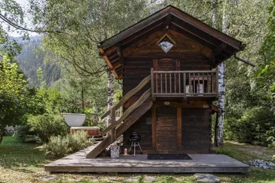 a tree house in the woods with a deck at Mazot les Tines in Chamonix-Mont-Blanc