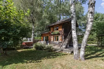 a log cabin in the woods with a tree at Mazot les Tines in Chamonix-Mont-Blanc
