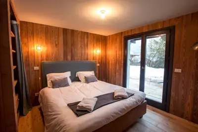 a bedroom with a bed with wooden walls and a window at Stunning Views Chamonix in Chamonix-Mont-Blanc