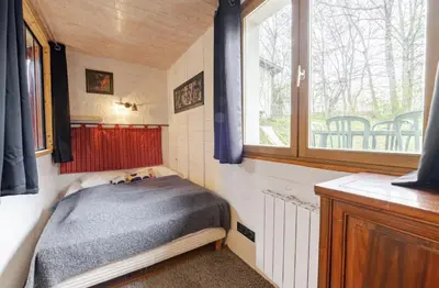 a small bedroom with a bed and a window at Chalet Cyclamens, 65m2 plein centre - Jardin, WIFI & parking! in Les Carroz d'Araches