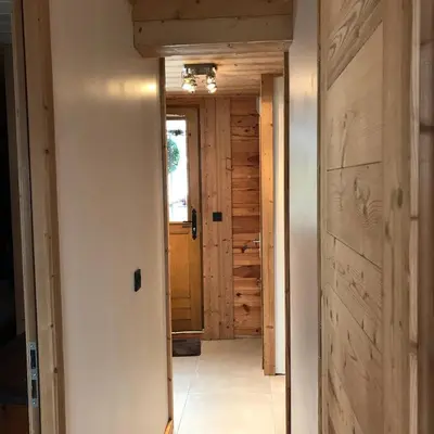 a hallway leading to a room with a door at Chalet Cyclamens, 65m2 plein centre - Jardin, WIFI & parking! in Les Carroz d'Araches