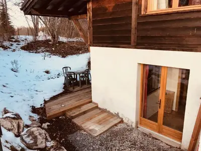 a porch of a cabin in the snow at Chalet Cyclamens, 65m2 plein centre - Jardin, WIFI & parking! in Les Carroz d'Araches