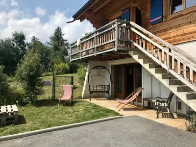 a porch of a house with a wooden staircase at Chalet Cyclamens, 65m2 plein centre - Jardin, WIFI & parking! in Les Carroz d'Araches