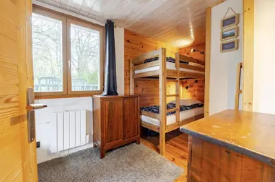 a bedroom with bunk beds in a wooden cabin at Chalet Cyclamens, 65m2 plein centre - Jardin, WIFI & parking! in Les Carroz d'Araches