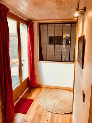 a room with a large window and a rug at Chalet Cyclamens, 65m2 plein centre - Jardin, WIFI & parking! in Les Carroz d'Araches