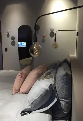 a bedroom with two lamps and a bed with pillows at Le petit M Chamonix au pied du Brévent in Chamonix-Mont-Blanc