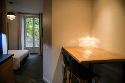 a room with a table and a bed and a window at Appart'Hotel Aiguille Verte & Spa in Chamonix-Mont-Blanc